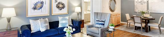 a living room with a blue couch and a ceiling fan at Bridgewater Apartment Homes, Brandon
