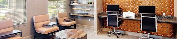 a lobby with two desks and chairs and a round table at Audubon Park Apartment Homes, LA, 70791