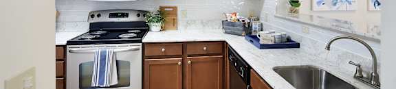 an apartment kitchen with stainless steel appliances and wooden cabinets at Landing at Willow Bayou in Bossier City, Louisiana 71111