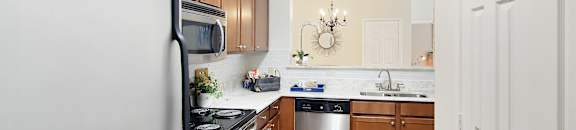 a kitchen with stainless steel appliances and wooden cabinets at Landing at Willow Bayou in Louisiana