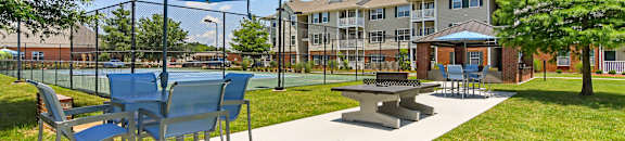 a picnic area with tables and umbrellas at The Madison Apartment Homes in TX 75703