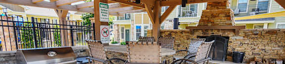 A patio with a fireplace and chairs at Wellington Grande Apartment Homes, Longview, TX, Texas, 75605