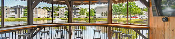 A wooden deck with a bar area and a view of a residential area at Reserve at Gulf Hills Apartment Homes in MS 39564