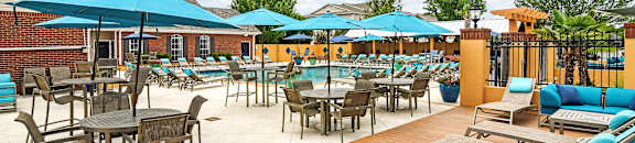 A patio with tables and chairs under umbrellas at Summit of Shreveport Apartments, Shreveport, 71105