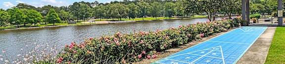 a tennis court on the grass next to a lake at Lakeshore Pointe Apartment Homes, Brandon, 39047