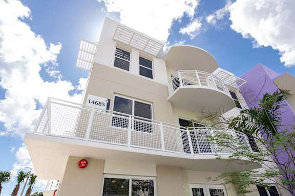 A white building with a red sign on the bottom left.