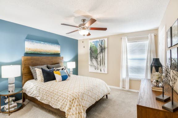 a bedroom with a bed and a ceiling fan at Crossgates Apartment Homes, Starkville