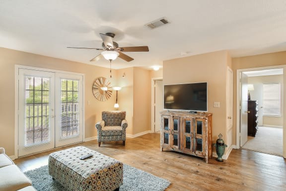 a living room with a couch and a ceiling fan at The Colony Apartment Homes, Columbus, 39702