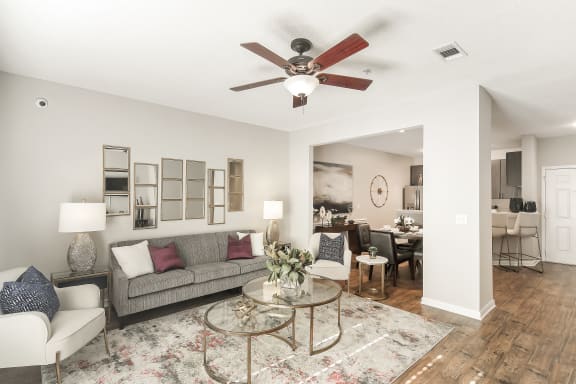 a large deck with trees and tables and chairs  at Lagniappe of Biloxi Apartment Homes, Biloxi, MS
