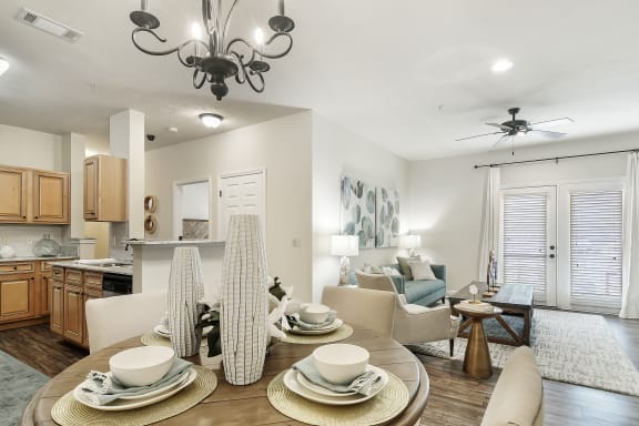 a rendering of a living room with a kitchen in the background at Charleston Apartment Homes, Mobile, AL