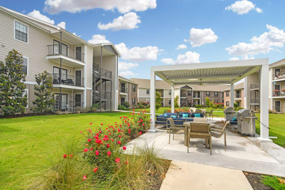 the entrance to a brick building with a sidewalk and landscaping at Parkwest Apartment Homes in Hattiesburg, MS 39402