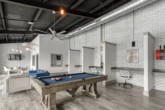 a swimming pool with chaise lounge chairs and a pool house in the background at Parkwest Apartment Homes in Hattiesburg, MS