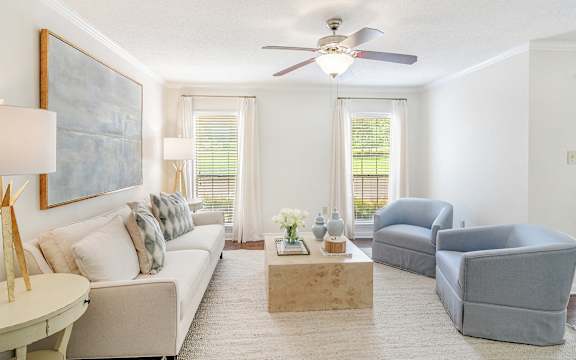 a living room with a ceiling fan and couches