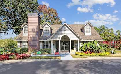 A house with a red brick chimney and a large front porch.