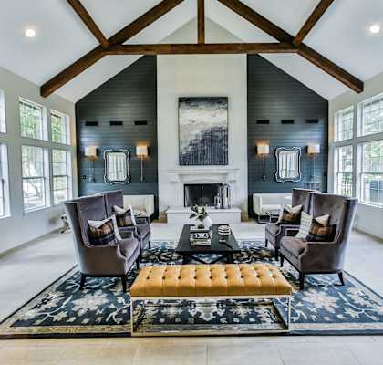 A large room with a fireplace and a rug in the middle.