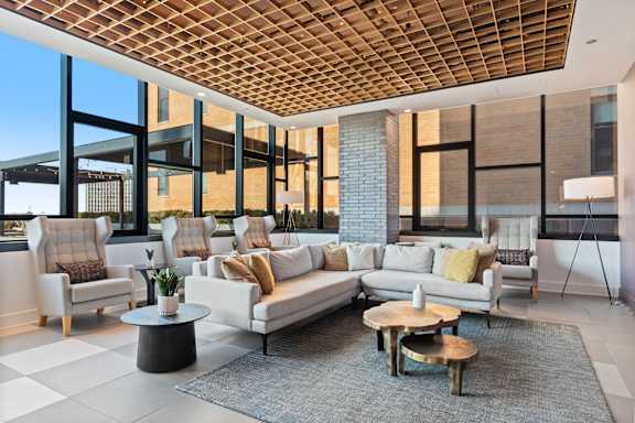 A modern living room with a wooden ceiling and white furniture.