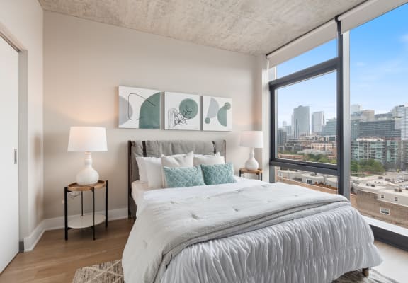 a bedroom with a large bed and a large window with a city view