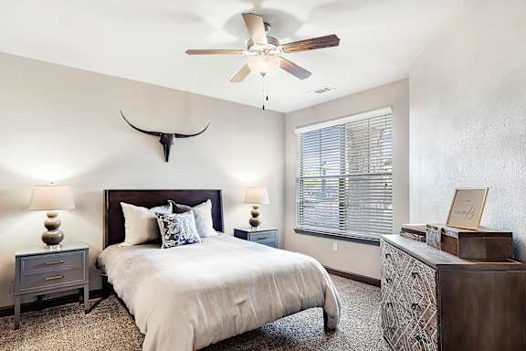 a swimming pool with chaise lounge chairs and a pool house in the background  at Wellington Grande Apartment Homes, Longview, TX