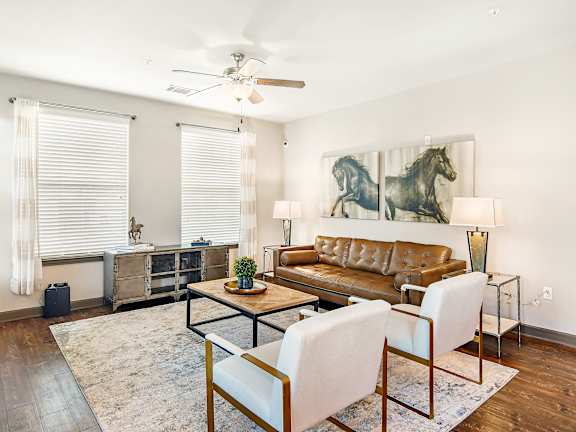 a living room with a couch and chairs and a ceiling fan  at Wellington Grande Apartment Homes, Longview