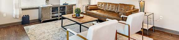 Living room with a leather couch at Wellington Grande Apartment Homes, Longview, TX
