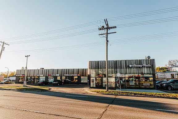 A Chicken Hut restaurant is located on a street corner with cars parked in front.