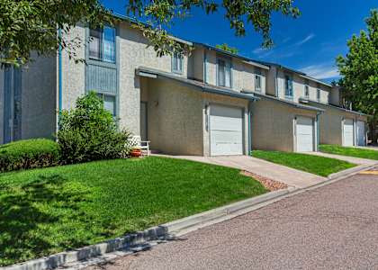 A row of apartment buildings with green lawns in front.