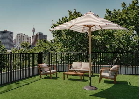 a patio with chairs and an umbrella on a balcony