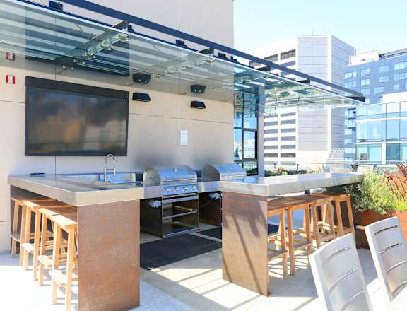 A modern outdoor kitchen with a bar area and seating.