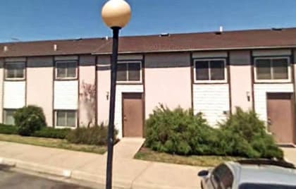 A street view of a residential area with apartment buildings.
