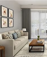 A living room with a white couch, a coffee table, and a flat screen TV.