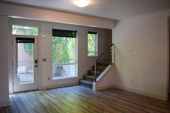 A room with a staircase and a door leading outside.