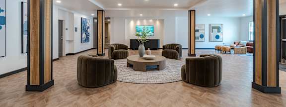A spacious living room with a central coffee table and multiple seating options.