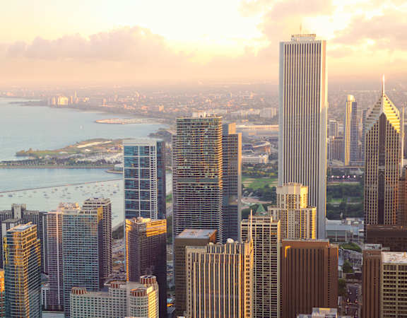 A city skyline with tall buildings and a body of water in the background.