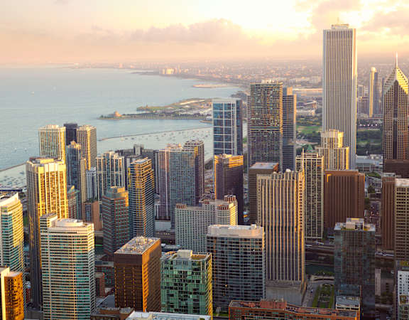 A city skyline with tall buildings and a body of water in the background.