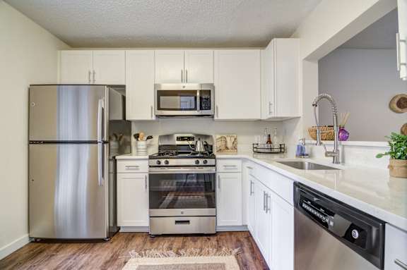 A kitchen with white cabinets and stainless steel appliances.