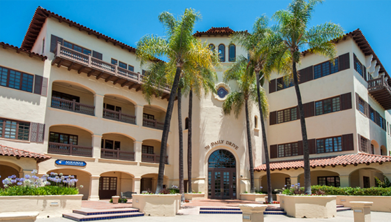 a large building with palm trees in front of it