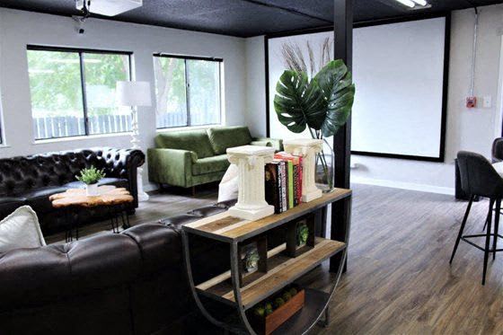 a living room with a leather couch and a book shelf at Capital Flats & Magnolia Square Apartments, Raleigh, NC, 27601