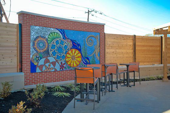 a mural on the side of a building with chairs