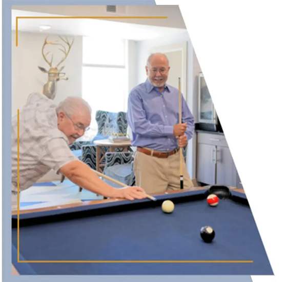 Two men playing pool in a room.