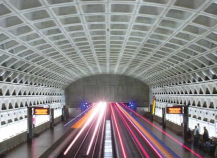 A long exposure shot of a train station with light trails from moving trains at The Atrium, Washington, DC, 20019