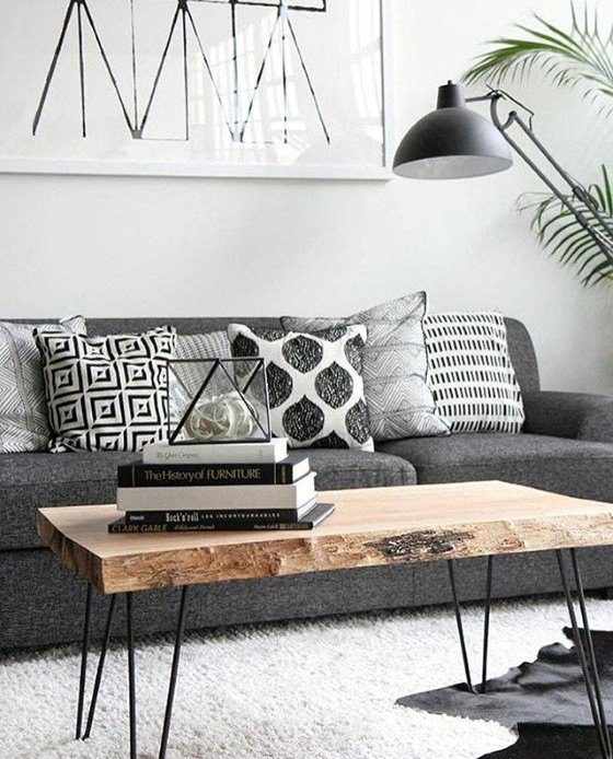 A grey couch with a wooden coffee table in front of it.