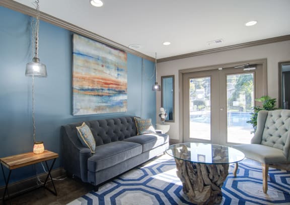 a living room with blue walls and a glass coffee table
