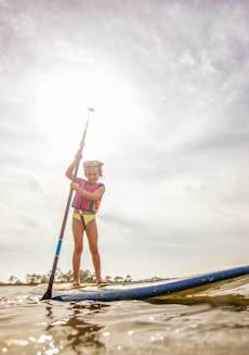 a woman standing on a paddle board in the water