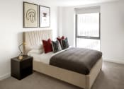 Thumbnail 9 of 12 - a bedroom with a bed and a large window