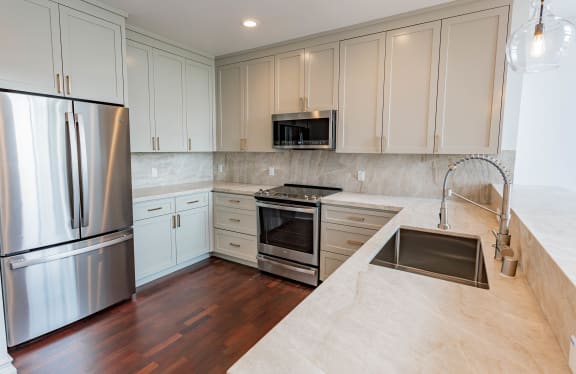 a kitchen with white cabinets and stainless steel appliances at Vendome Place, California