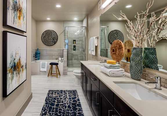 A bathroom with a large mirror, a sink, and a rug.