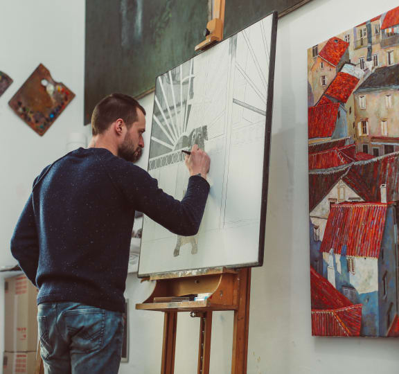 A man is painting a picture on a canvas at The Rey Downtown, Phoenix, 85003