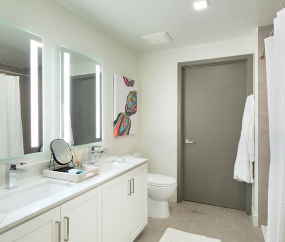 A bathroom with a toilet, sink, and mirror.