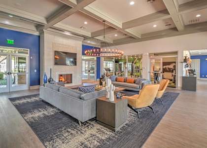 a living room with couches and chairs and a fireplace at The Atlantic Stonebriar, The Colony, TX 75056