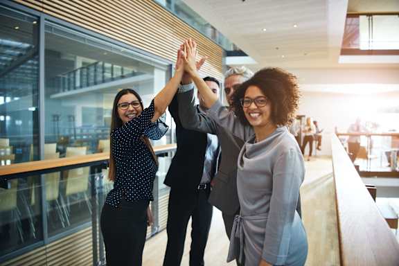 Three people giving each other a high five.